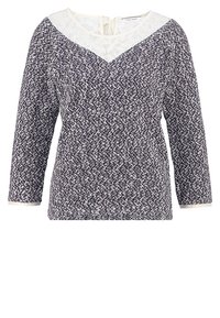 Långärmad topp med ett marinblått och vitt blommönster; har en spetskrage och detalj med nyckelhål bak. Mjuk tyg med en texturerad yta.