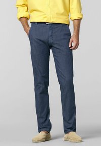 Marineblå chinos med lige snit og sidelommer, parret med en gul knap-op skjorte og beige espadriller. Glat stoftekstur.