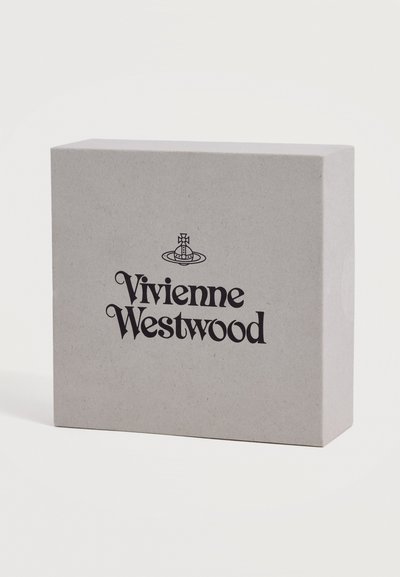 Μπεζ ορθογώνιο κουτί με το λογότυπο Vivienne Westwood και το έμβλημα σφαίρας στο κέντρο μπροστά σε μαύρο.