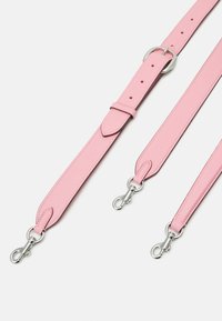 Ceinture en cuir rose à finition texturée, matériel argenté, longueur réglable, et deux clips pivotants pour fixation.