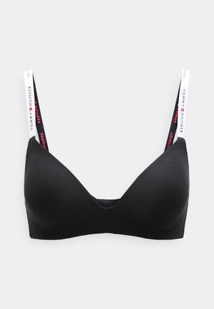 Black soft cup bra with a plunging neckline, adjustable straps featuring "TOMMY HILFIGER" branding in red and white on the straps.