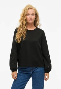 Felpa nera a maniche lunghe con motivi floreali in cut-out sulle maniche, realizzata in tessuto morbido, con scollatura rotonda e vestibilità rilassata.