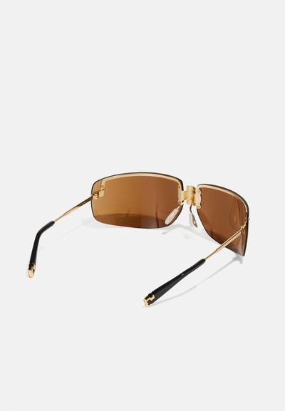 Lunettes de soleil teintées marron avec une forme rectangulaire, monture en métal doré, branches en acétate noir et accents matériels détaillés.