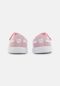 Roze tenisice s bijelim detaljima, s gornjim dijelom od mrežastog materijala, podstavljenim ovratnikom i trakama na čičak. Istaknut logo na peti.