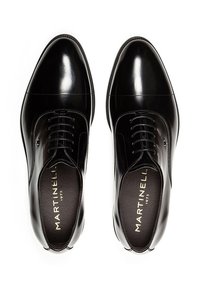 Zapatos de vestir de cuero negro con un acabado suave, punta redondeada y diseño con cordones. Presenta una marca minimalista y detalles de costura sutiles.