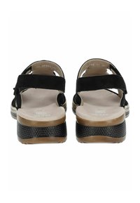 Sandali neri in suede con doppie cinghie, suola nera texturizzata e soletta beige imbottita. Presentano un leggero tacco a zeppa per un rialzo.