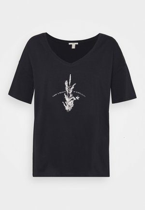 T-shirt noir à col en V et manches courtes avec illustration botanique blanche et texte ""There's beauty in simplicity"" centré sur le devant.