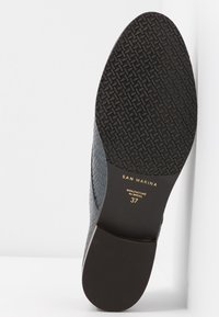 Semelle de chaussure en cuir noir avec bande de roulement texturée, marquée "San Marina", taille 37, fabriquée au Brésil.
