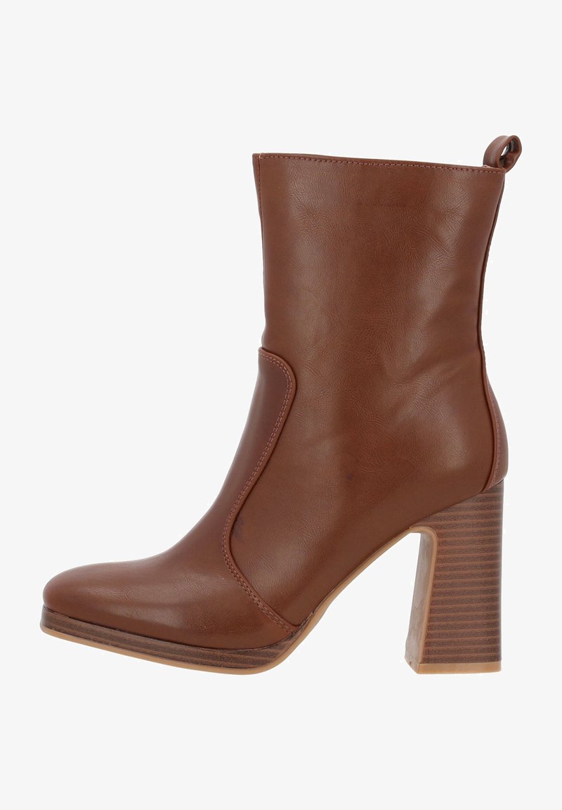 Bottine en cuir marron avec bout arrondi, talon bloc et une languette à l’arrière.