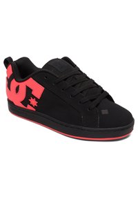Zapatillas de skate negras con suela plana, que presentan un gran logotipo rosa y detalle de estrella. Fabricadas en material textil con cordones negros.
