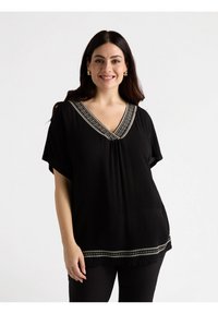 Blusa nera con maniche corte e scollo a V, con un bordo decorativo in argento lungo lo scollo e l'orlo. Tessuto leggero.