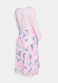 Vestido de mangas compridas com um corpete rosa claro, uma saia fluida com padrões em aquarela azuis e rosas, e um detalhe de cintura ajustada.