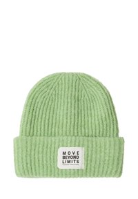 Prążkowana dzianinowa czapka w jasnej zieleni z podwiniętym mankietem. Na przodzie znajduje się etykieta z napisem "MOVE BEYOND LIMITS". Miękka w dotyku.