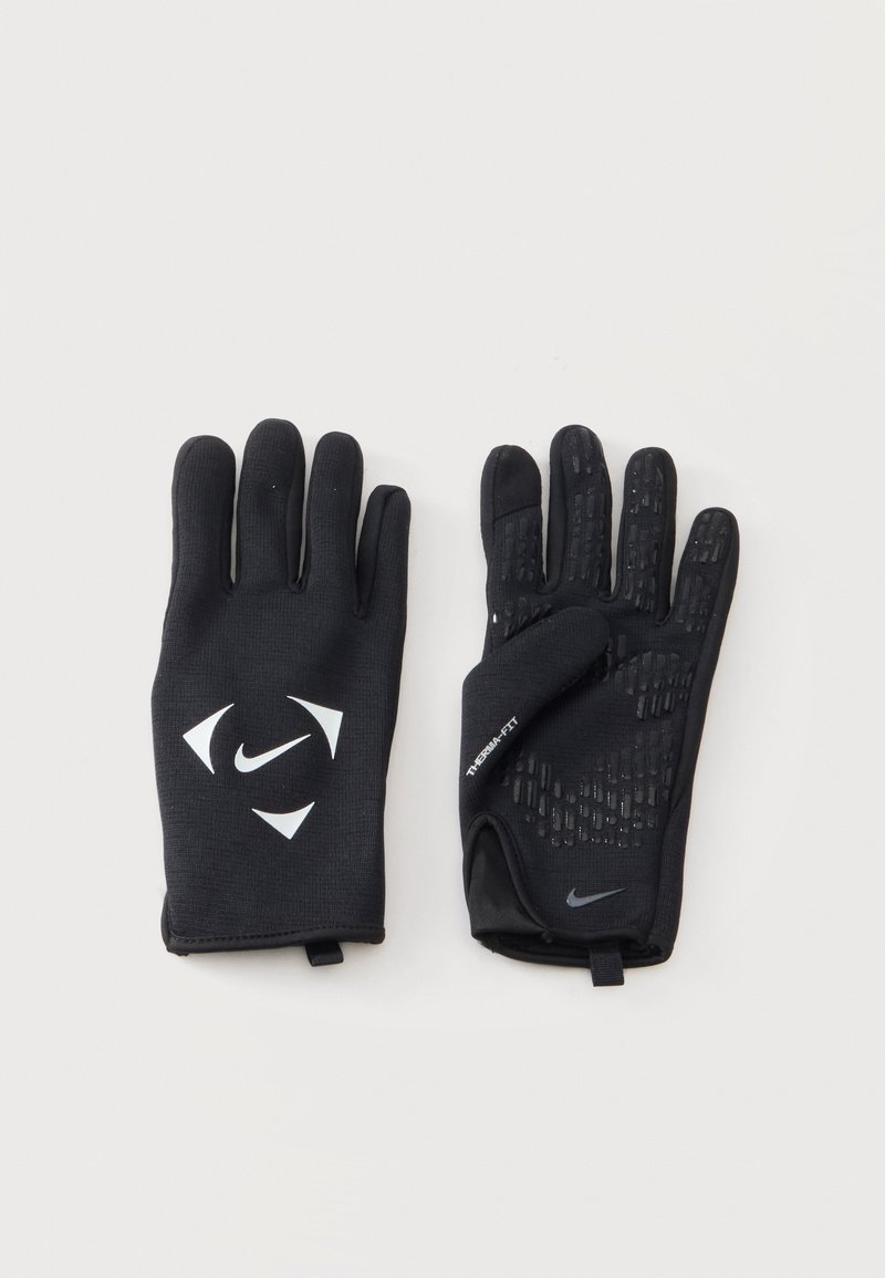Ζευγάρι μαύρα γάντια Nike με υφή για καλύτερη λαβή στις παλάμες και λευκά λογότυπα Nike στην πίσω πλευρά και τις περιοχές του καρπού, τοποθετημένα επίπεδα σε ανοιχτή επιφάνεια.