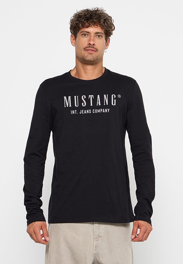 Czarna koszulka z długim rękawem z białym napisem "MUSTANG INT. JEANS COMPANY". Wykonana z bawełny o gładkiej fakturze i okrągłym dekoltem.