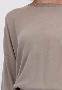 Langarmtop van zacht, lichtgewicht materiaal in een gedempte taupe kleur. Beschikt over een ronde halslijn met een gestructureerde rand. Relaxte pasvorm.