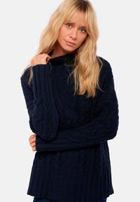 Pull en tricot torsadé marine avec une coupe décontractée, col roulé et poignets côtelés. Présente des motifs texturés et un tissu doux et confortable.