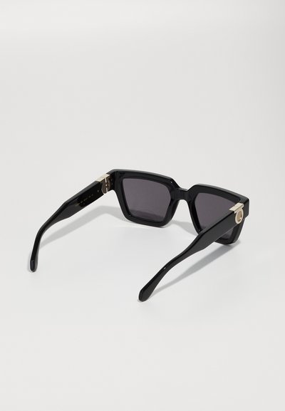 Black rectangular sunglasses with dark lenses, featuring a gold accent on the temple, and sleek, smooth plastic arms.