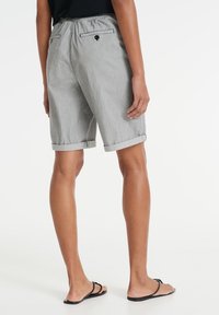 Šedé šortky s ohrnutými lemy, elastickým pasem a dvěma zadními kapsami, s jemnou pruhovanou texturou a černým knoflíkovým detailem.