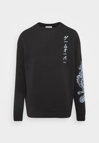 Sweat-shirt noir avec texte japonais blanc sur la poitrine et une illustration détaillée de dragon blanc sur la manche droite.