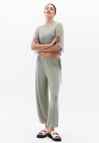 Ljusgrön tvådelad outfit med en lös, kortärmad topp och vida byxor med elastisk midja och dragsko.