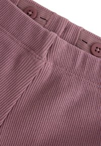 Ribbed, mauve kangas, jossa on kaksi ruskeata nappia vyötäröllä. Ominaisuuksina teksturoitu pinta ja näkyvät ompeluyksityiskohdat.