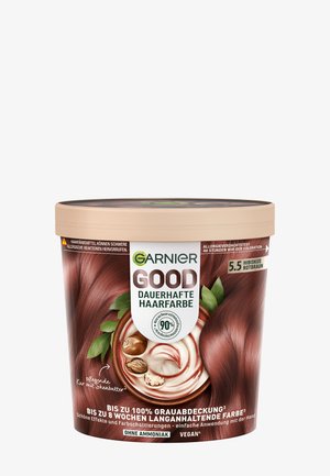 La tintura per capelli Garnier Good in un contenitore rotondo marrone presenta un colore rosso-marrone, una consistenza cremosa e liscia, e un design con una foglia verde come accento.