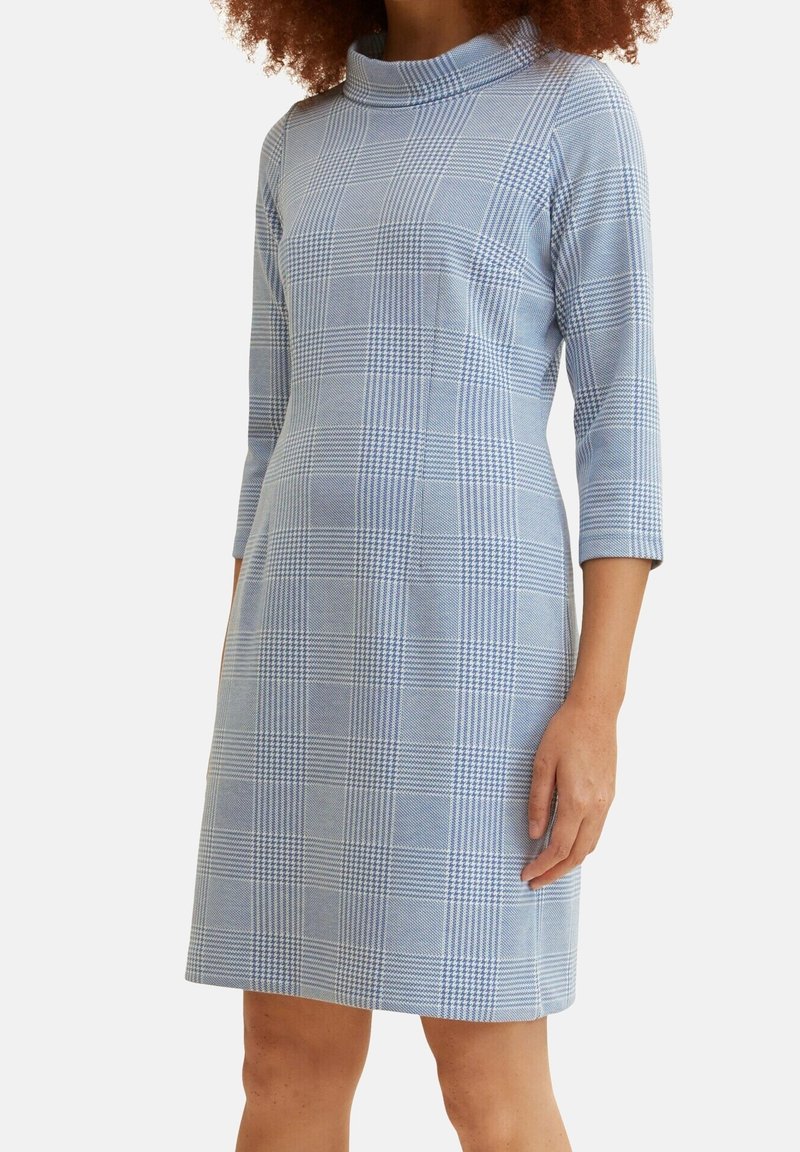 Vestido a cuadros azul con un cuello alto, mangas tres cuartos y un diseño ajustado. La tela tiene una textura suave y una silueta estructurada.