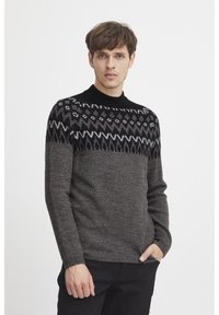 Grau gestrickter Pullover mit einem schwarz- und hellgrau gemusterten Schulterbereich. Runder Ausschnitt, lange Ärmel und eine weiche Textur. Schlichtes, tailliertes Design.