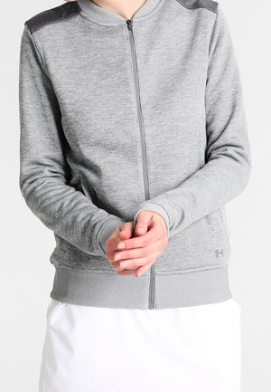 Felpa grigia chiara con zip, dettagli neri sulle spalle, polsini e orlo a coste, caratterizzata da una texture morbida e una vestibilità ergonomica.
