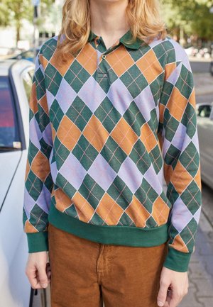 Langärmeliges Poloshirt mit einem mehrfarbigen Rautenmuster in Grün, Orange und Hellviolett sowie einem grünen Kragen und Saum.