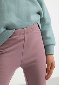 Lyseblå sweatshirt og lyserøde leggings, blød bomuldsblanding, med et tætsiddende design, elastisk talje og glat tekstur.