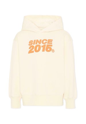 Kremowa bluza z kapturem z pomarańczowym, pogrubionym napisem „SINCE 2015” na piersi, wyposażona w długie rękawy i przednią kieszeń kangurka.