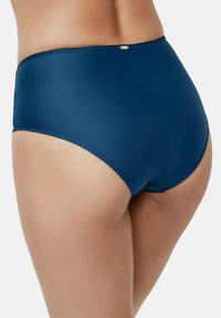 Hoge taille zwemonderzijde in donkerblauw, met een textuurstof. Voorzien van een gladde tailleband en een kleine gouden hardware-accent. Naadloos ontwerp.