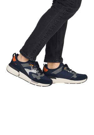 Baskets de sport navy avec des accents gris et orange, dotées d'une tige lisse, d'un bout rond, de lacets texturés et d'une épaisse semelle blanche.