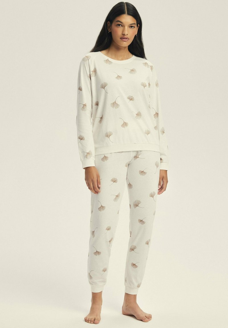 Long-sleeve, crewneck top and matching pants in light beige fabric with leaf print, featuring ribbed cuffs and elastic waistband.