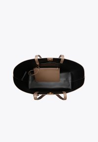 Borsa a spalla in pelle nera con manici beige e una piccola tasca interna marrone. Texture liscia, forma rotonda e un accento in metallo dorato.