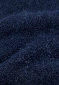 Marineblå ullstoff med en myk, teksturert overflate og synlige fibre som gir et litt frette utseende, arrangert i milde folder.