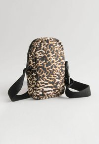 Mini taška s leopardím vzorom a zipsom, čierny tkaný popruh a kompaktný tvar. Mäkšia látka s hladkou textúrou a kontrastnými farbami.
