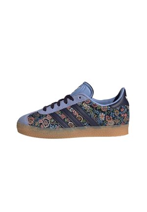 Lage sneaker met bloemmotief stof, blauwe suède accenten, zwarte strepen, zwarte veters en een zool van gumrubber.