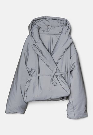 Lys grå puffjakke med oversized pasform, hætte og indviklet design. Har et bælte med sløjfe og en glat, blank stofstruktur.