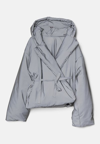 Světle šedá péřová bunda s oversize střihem, kapucí a obálkovým designem. Má stahovací pásek a hladkou, lesklou texturu materiálu.