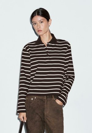 Polo à manches longues rayé en marron foncé et blanc, avec un col, une coupe décontractée et des détails de boutons au niveau du col.