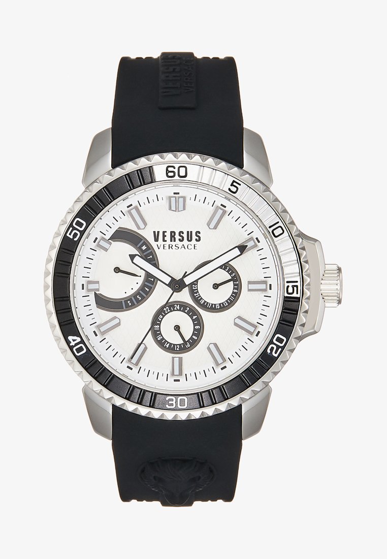 Reloj Versus Versace con caja plateada, bisel negro, esfera blanca texturizada, múltiples subesferas y una correa de goma negra con detalle de cabeza de león.