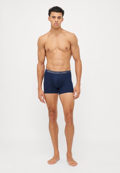 Marineblå bokserboksershorts lavet af strækbart stof, med en logo-bund. Designet er tætsiddende med en medium højde og glat tekstur.