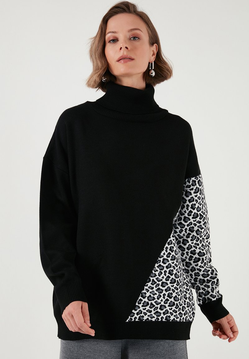 Pulover negru cu guler înalt, având un mare triunghi cu imprimeu leopard pe o parte. Realizat dintr-un material tricotat cu manșete și tiv zimțat.
