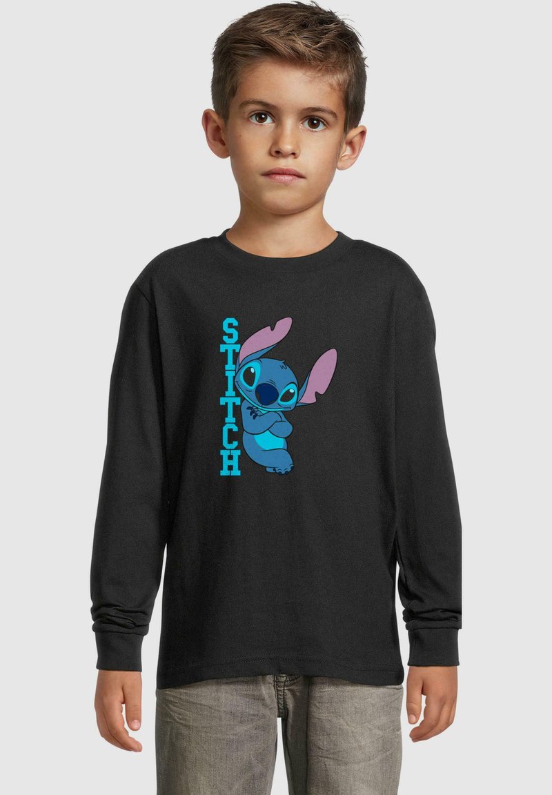 Čierna košeľa s dlhým rukávom a modrou kreslenou postavičkou, Stitch, s nápisom "STITCH" v modrom texte na ľavej strane. Mäkká tkanina, voľný strih.