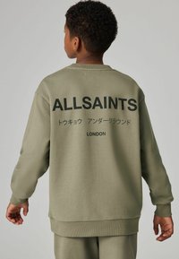 Zeleni dukserica od mekanog materijala ima kroj s okruglim izrezom, opušten fit i upečatljiv crni natpis "ALLSAINTS" na leđima.