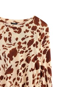 Maglietta beige a maniche lunghe con macchie irregolari marroni che ricordano una stampa di mucca, con scollatura tonda e etichetta del marchio Lindex.