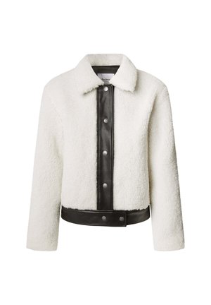 Krémová shearling bunda s čiernou koženou prednou časťou, cvokmi a golierovým výstrihom. Textúrovaná tkanina s kontrastnými akcentmi.